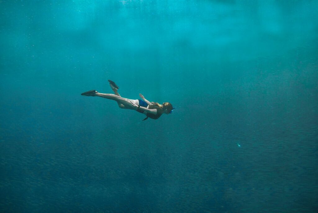 photo of woman swimming underwater